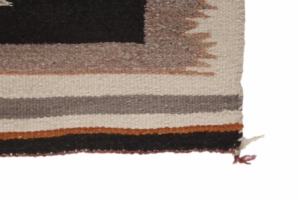 Artwork by Mae Benally, Navajo Eye Dazzler Crownpoint rug, Made of Dyed colors of light brown, black, grey, heathered grey, and cream set to a black field.