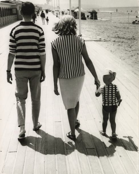 Family walking on the boards at Deauville by René Maltête, circa 1960