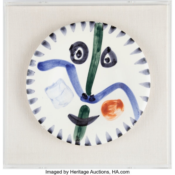 A decorative plate with a face painted on it.