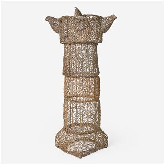 A tall, wireframe sculpture resembling a stylized figure with outstretched arms.