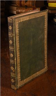 An antique book with ornate gold detailing on a dark green cover.