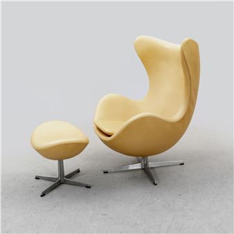 A sleek, pale yellow lounge chair and ottoman set against a neutral gray background.