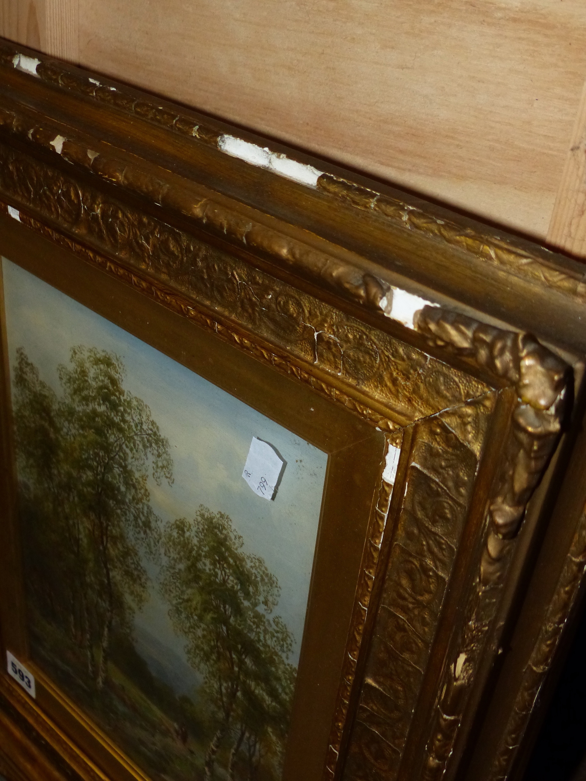 A framed landscape painting of birch trees in a field under an overcast sky.