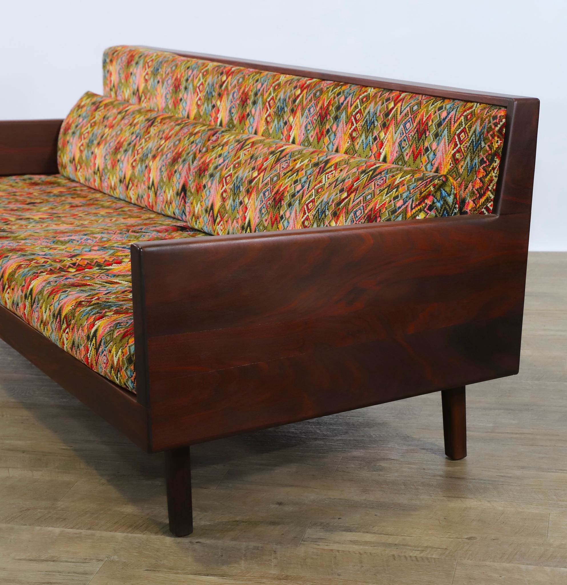 Artwork by Harvey Lowe, Sofa on slightly tapered square legs with multicolored diamond flame upholstered removable seat and back cushions, Made of olive green upholstery