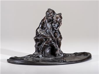A dark bronze sculpture of two intertwined figures resting on a rocky base.