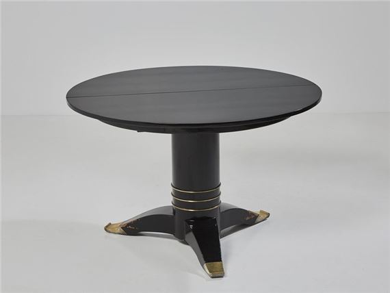 A black lacquered wood dining table with a circular top by Jules Leleu, dated 1941