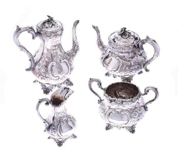 FOUR PIECE IRISH SILVER EMBOSSED TEA SERVICE WITH FLORAL FINIAL. by John Smyth, 1866