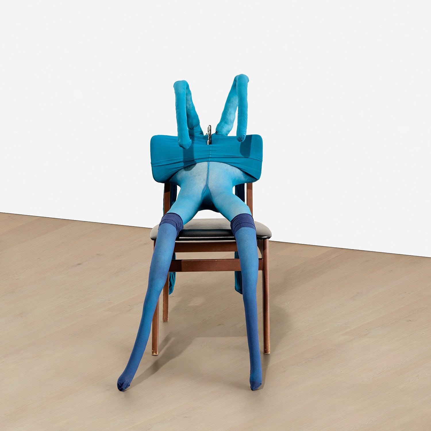 Artwork by Sarah Lucas, Bunny Gets Snookered #8, Made of blue tights, navy stockings, wood and vinyl chair, clamp, kapok and wire