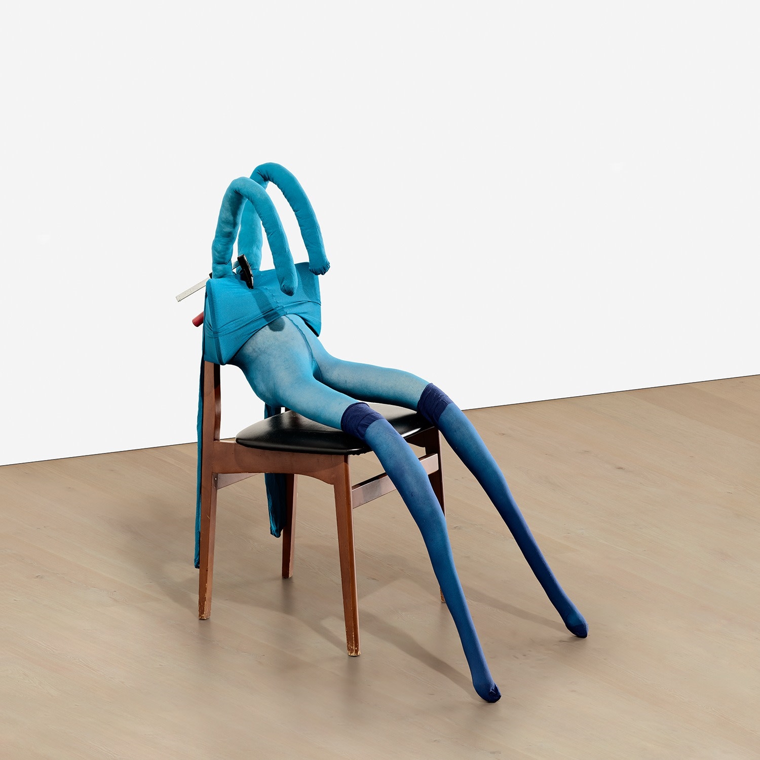 Artwork by Sarah Lucas, Bunny Gets Snookered #8, Made of blue tights, navy stockings, wood and vinyl chair, clamp, kapok and wire