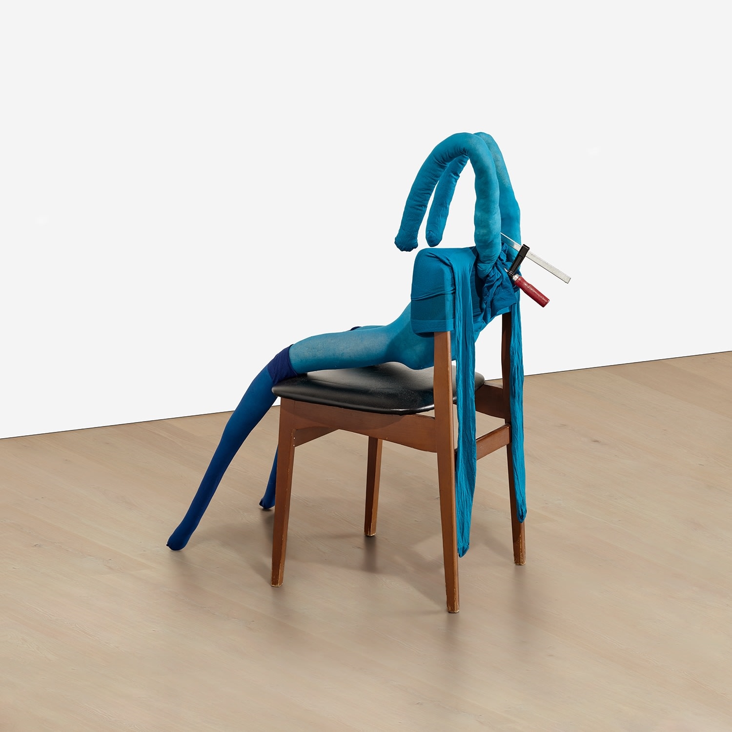 Artwork by Sarah Lucas, Bunny Gets Snookered #8, Made of blue tights, navy stockings, wood and vinyl chair, clamp, kapok and wire