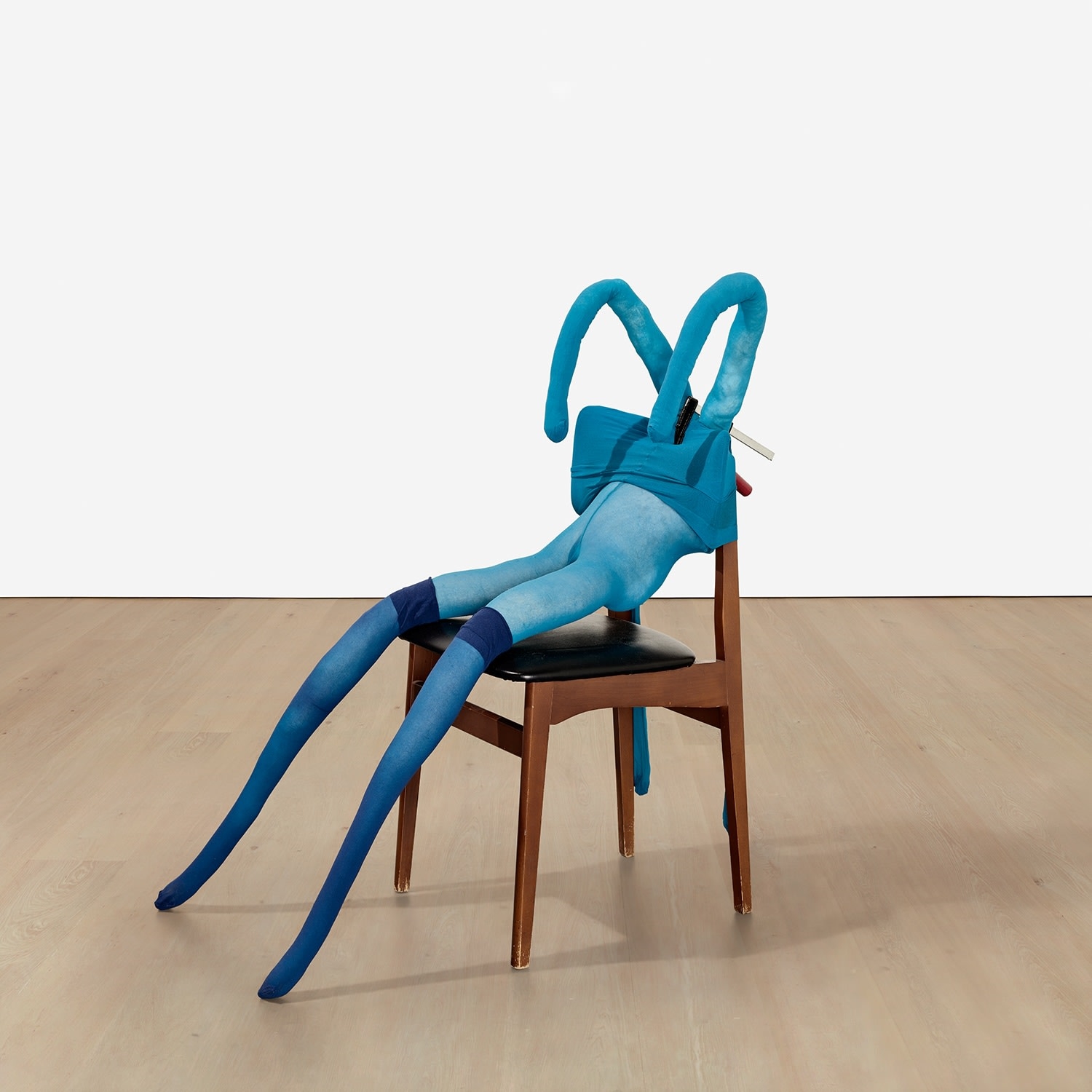 Artwork by Sarah Lucas, Bunny Gets Snookered #8, Made of blue tights, navy stockings, wood and vinyl chair, clamp, kapok and wire