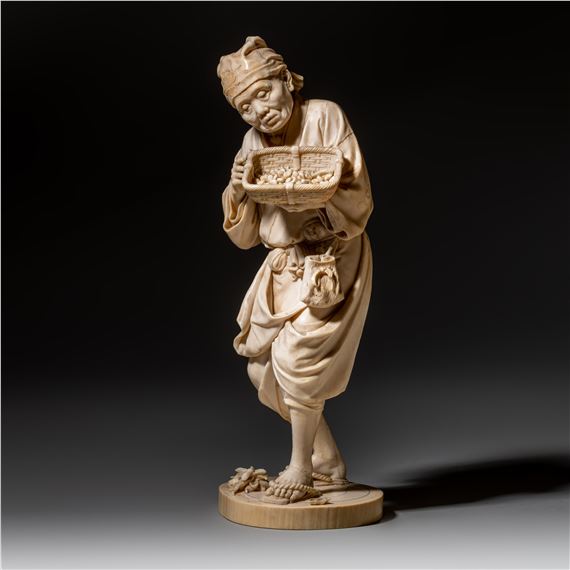 A rare lively sculpted Japanese Meiji period ivory okimono showing an old farmer