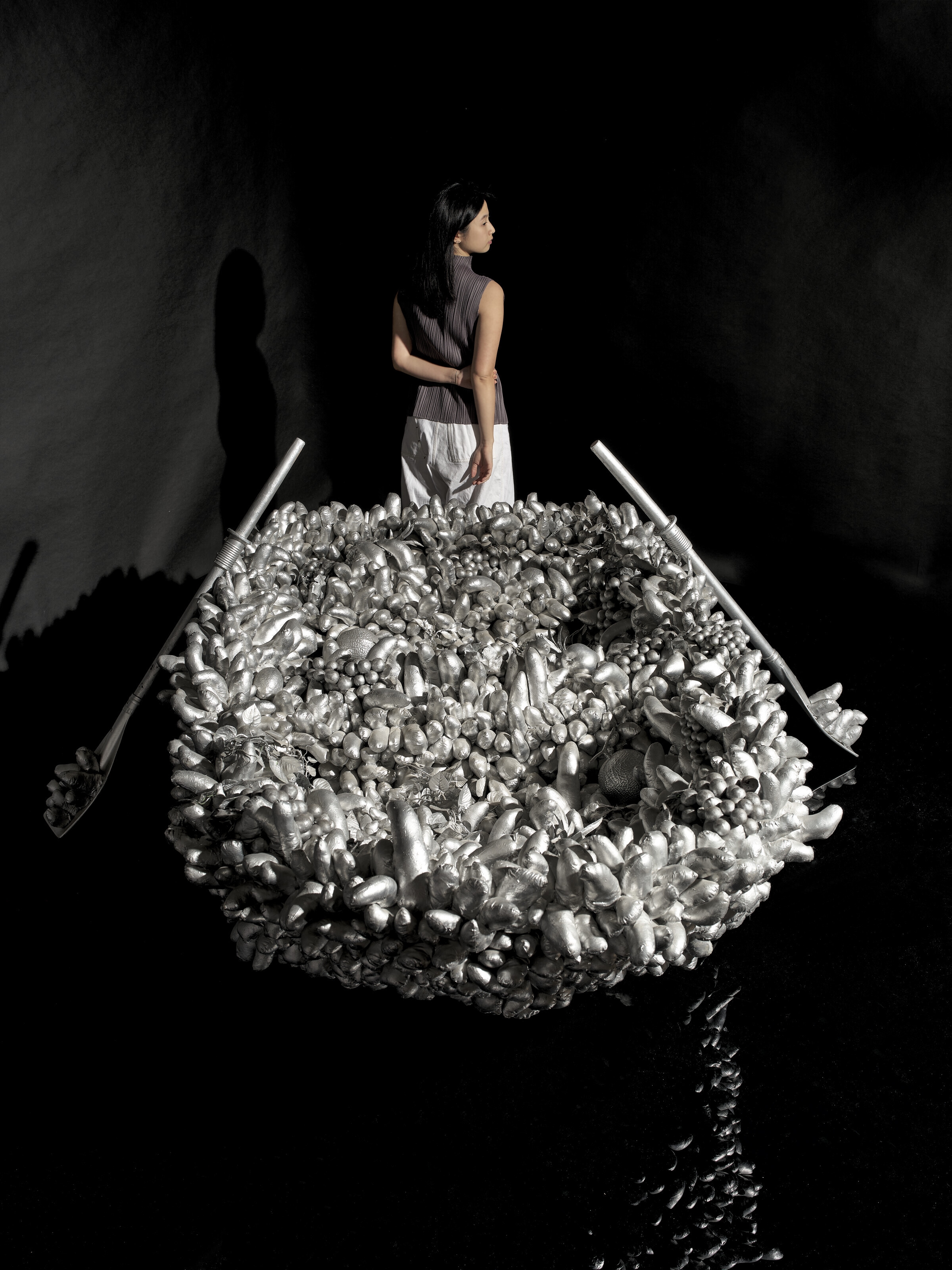 Artwork by Yayoi Kusama, Walking on the Sea of Death, Made of sewn stuffed fabric, plastic fruits, fiberglass rowboat, silver paint sculpture