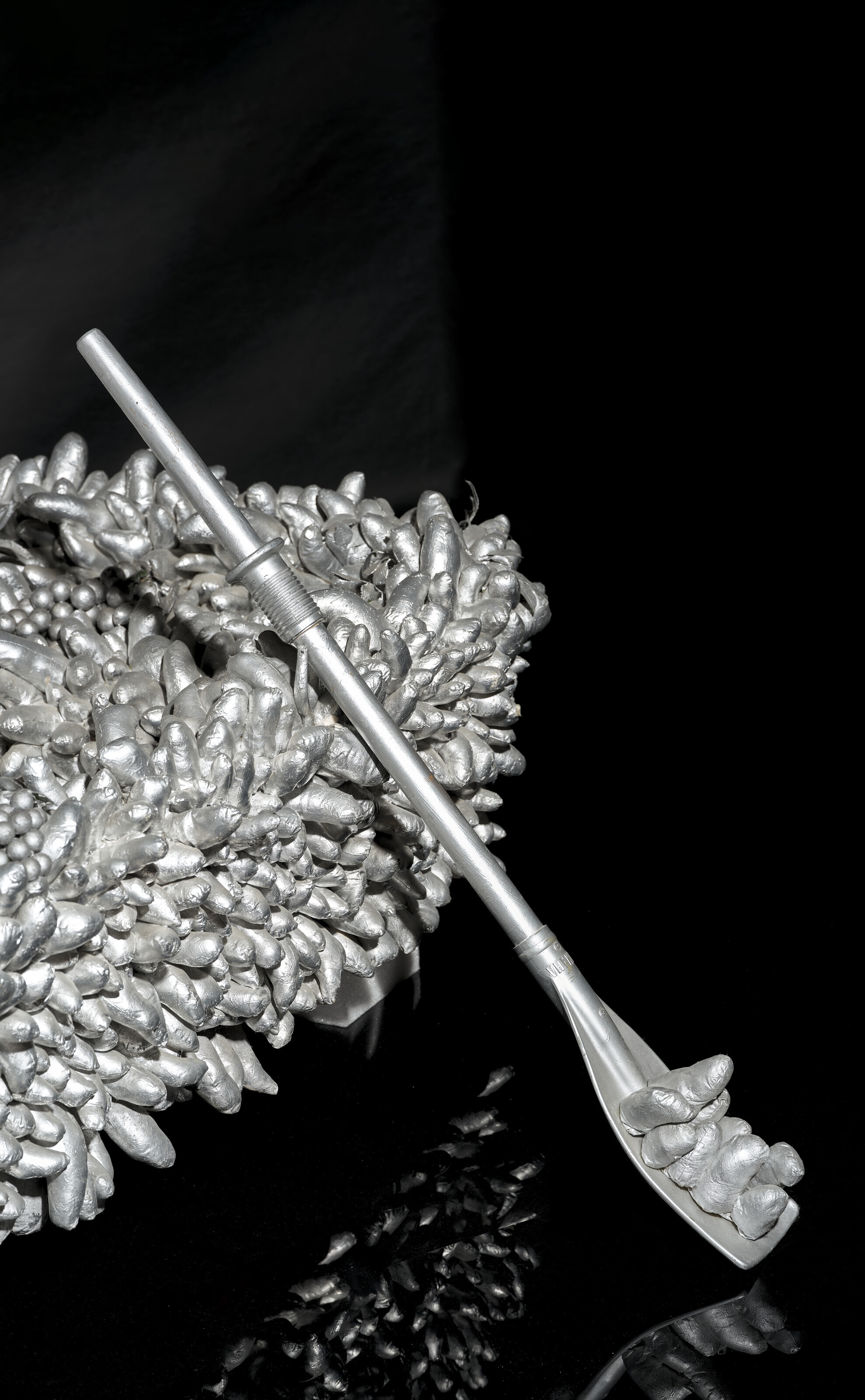 Artwork by Yayoi Kusama, Walking on the Sea of Death, Made of sewn stuffed fabric, plastic fruits, fiberglass rowboat, silver paint sculpture