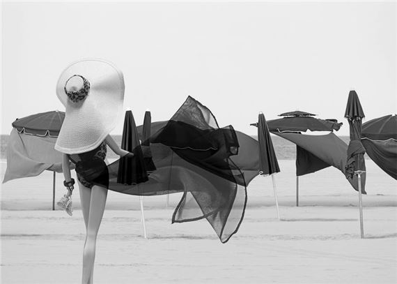Barbie® of collection dressed in her bathing suit and her black sarong flying on the beach of Deauville