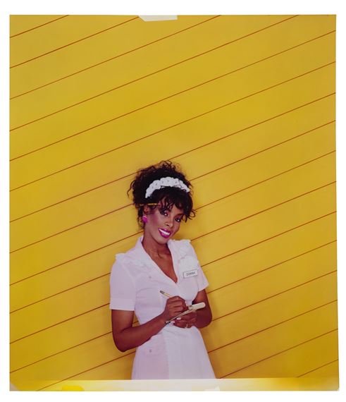 A portrait of a person in a white uniform against a bold yellow background.