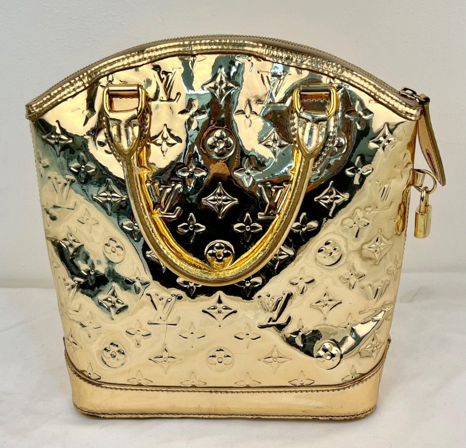 Louis Vuitton | A Louis Vuitton Lockit Monogram Gold-Tone Mirrored ...