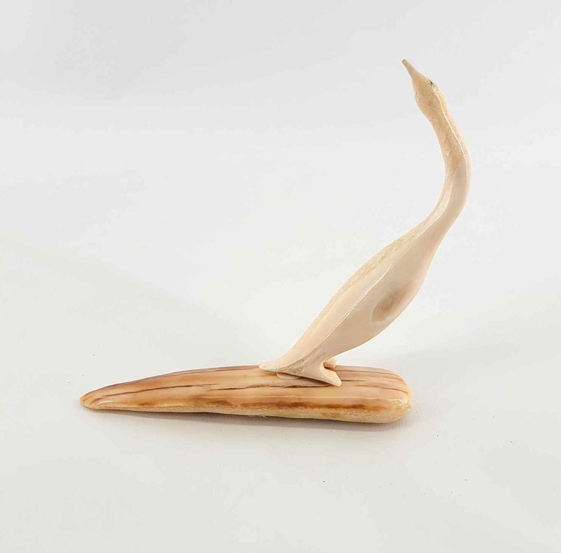 Artwork by Gene Apatiki, Cormorant, Made of figurine carved from walrus ivory, set upon amber-striated ivory