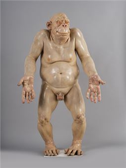 A life-sized, pale sculpture of a humanoid figure with an exaggerated, grotesque expression.