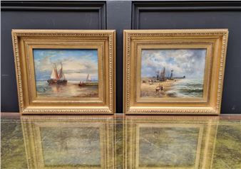 A pair of framed maritime paintings depicting coastal scenes with sailing vessels.