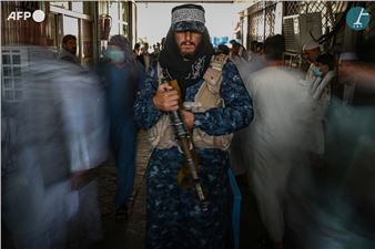 Taliban fighter standing guard in a market. Kabul - Aamir Qureshi