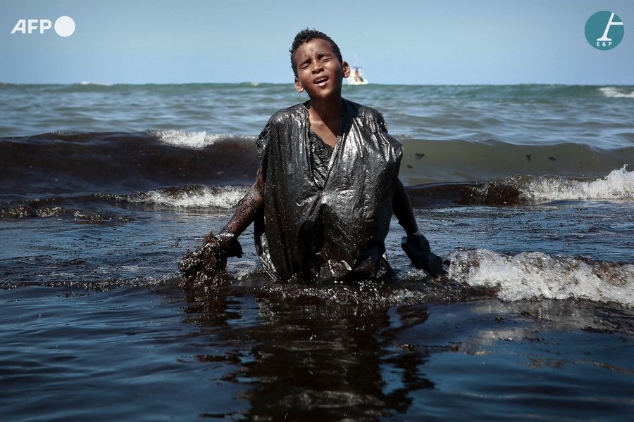 Artwork by Leo Malafaia, Child coming out of the water during an oil clean-up operation on Itapuama beach, Made of Pigment print on Hahnemühle baryta paper