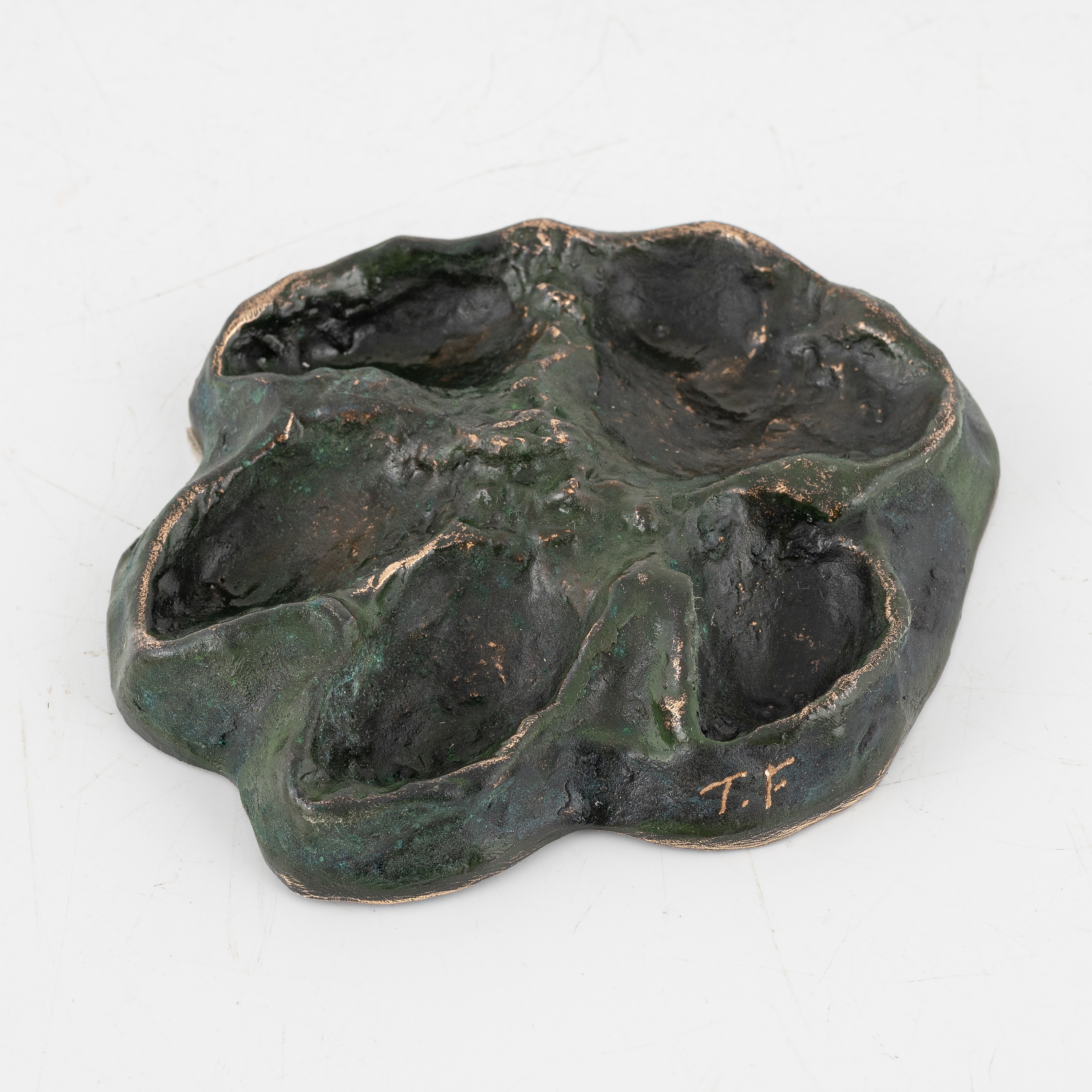 Artwork by Torbjörn Forsberg, A wolfs footprint, Made of Bronze, gold- and green patina