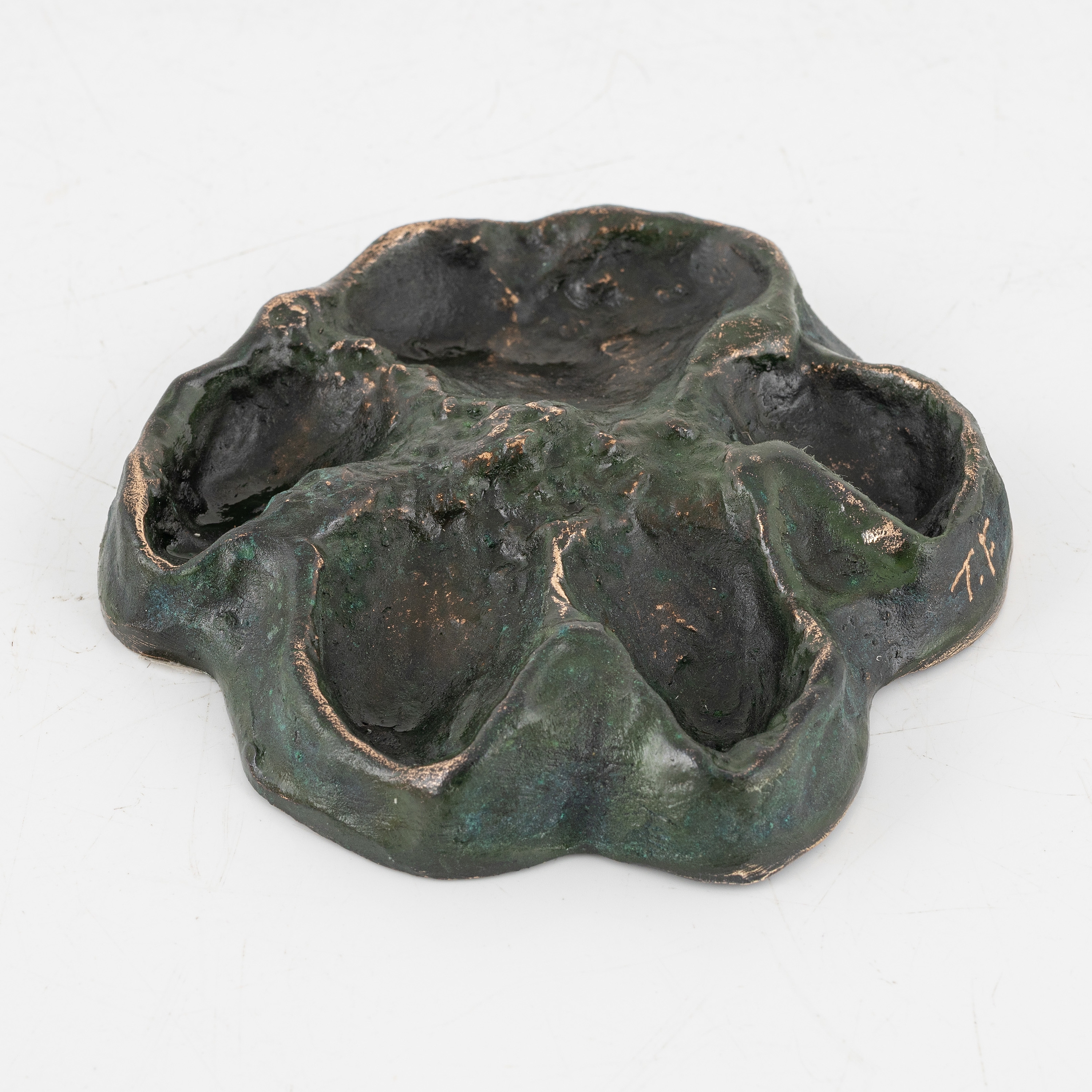 Artwork by Torbjörn Forsberg, A wolfs footprint, Made of Bronze, gold- and green patina