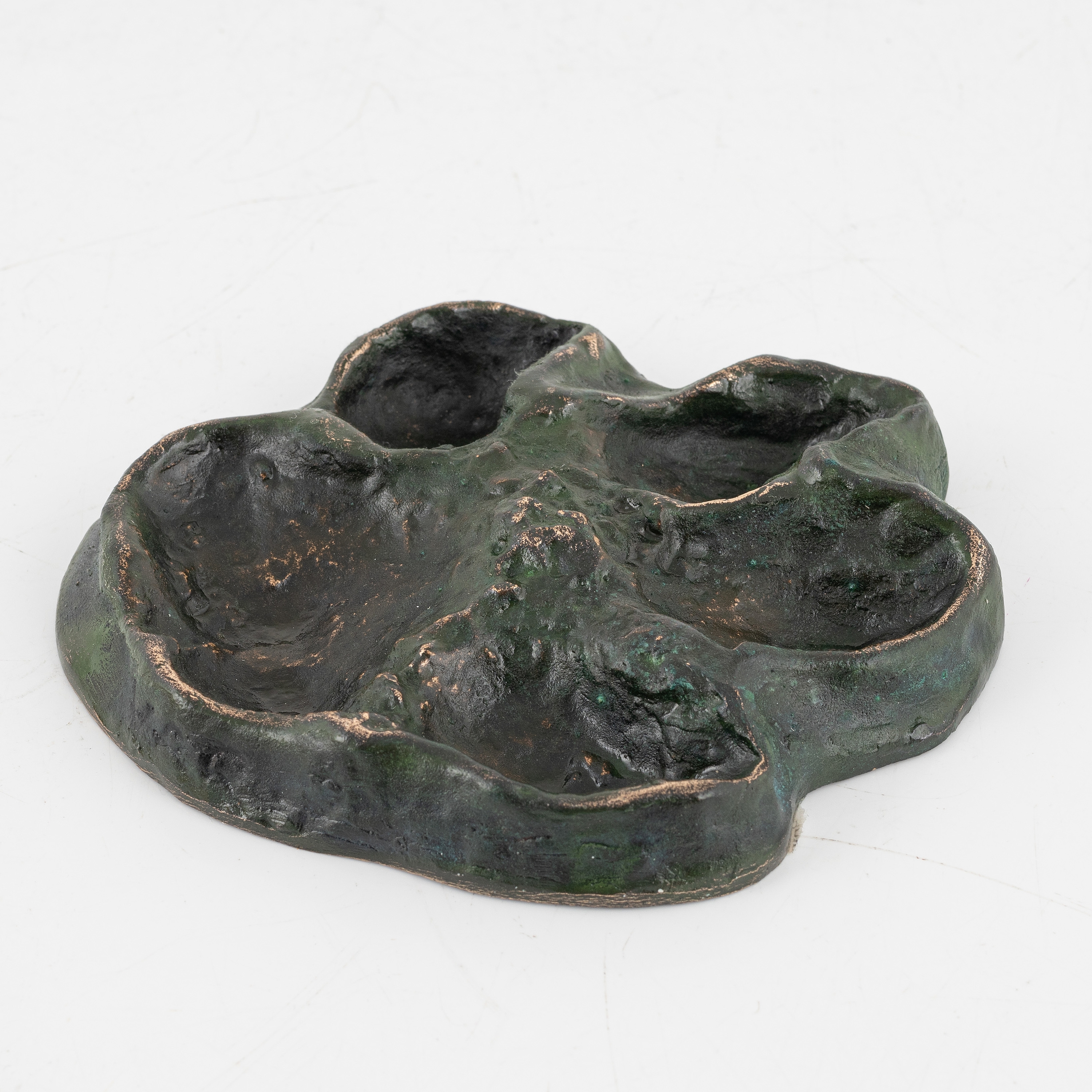 Artwork by Torbjörn Forsberg, A wolfs footprint, Made of Bronze, gold- and green patina