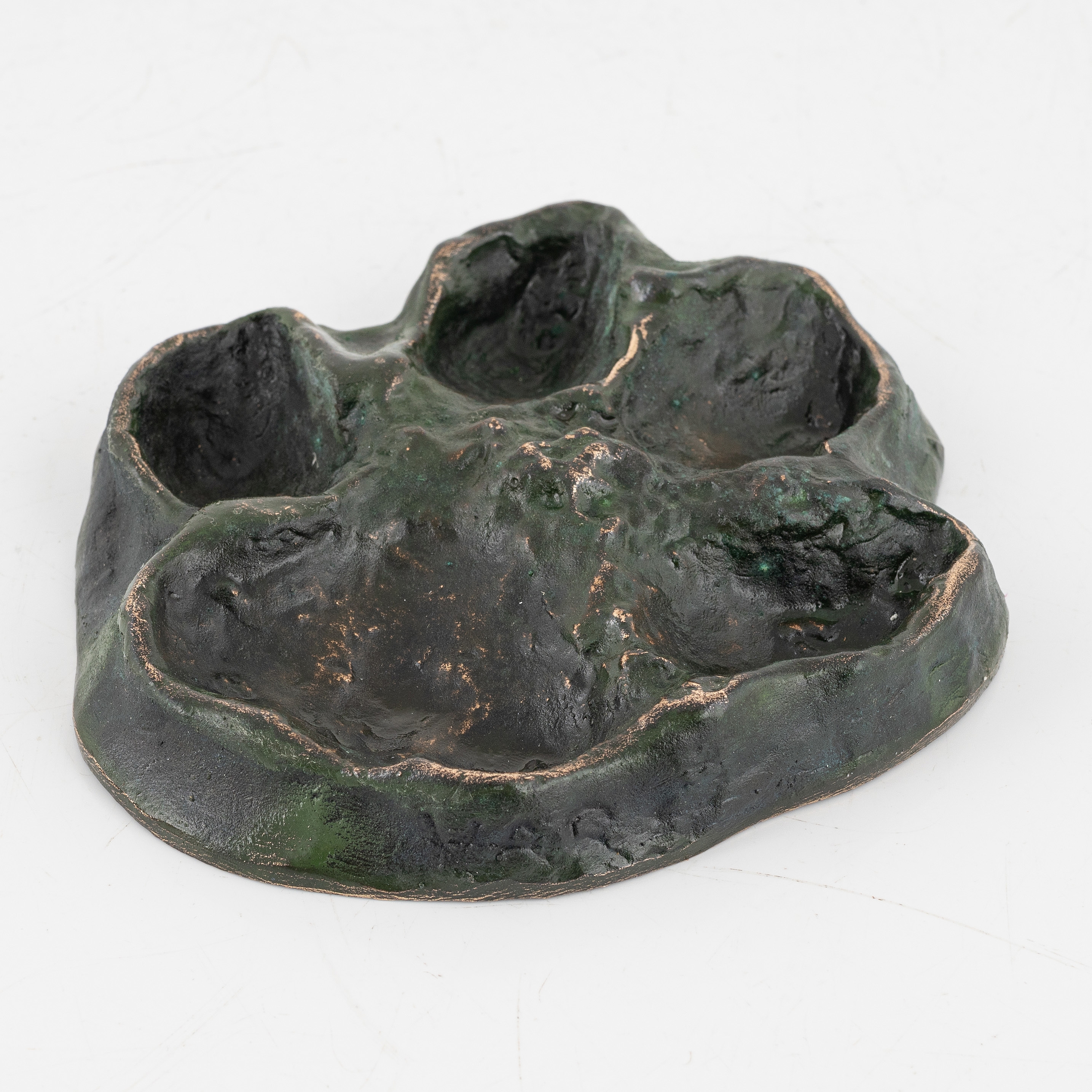Artwork by Torbjörn Forsberg, A wolfs footprint, Made of Bronze, gold- and green patina