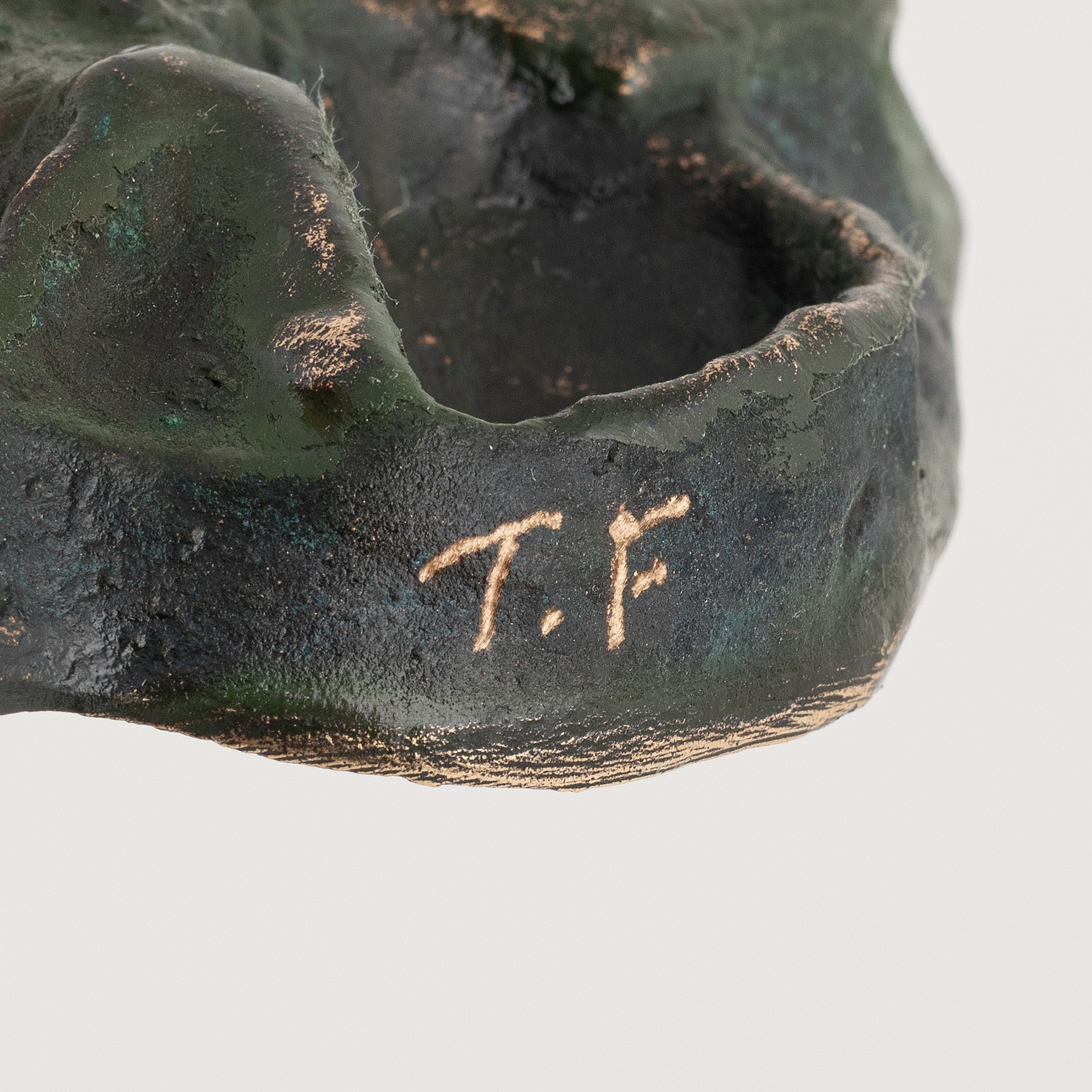 Artwork by Torbjörn Forsberg, A wolfs footprint, Made of Bronze, gold- and green patina