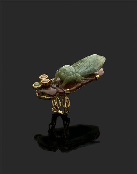 Jean VENDOME (1930-2017)
Yellow gold ring set with a two-tone jade jadeite cicada beneath an opalized agate motif, clasped with two brown diamonds and a brilliant-cut peridot.
Marked 1995
Weight: 36.5 g
TD. 53
Model specially made for Madame Stettiner.
