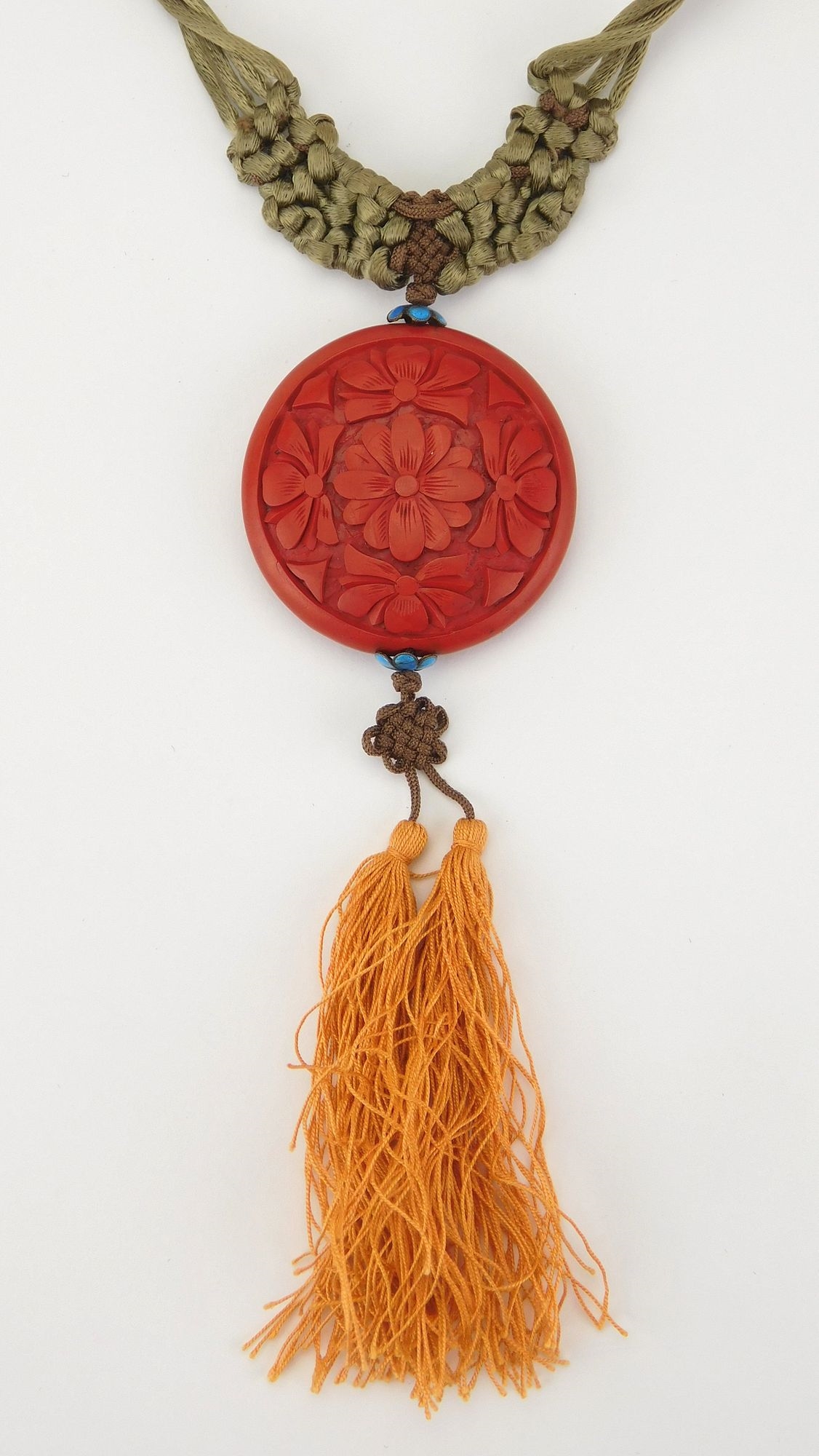 Artwork by Simone Samuels, Macramé and cinnabar necklace- intricately woven necklace with a carved cinnabar round pendant, Made of carved cinnabar