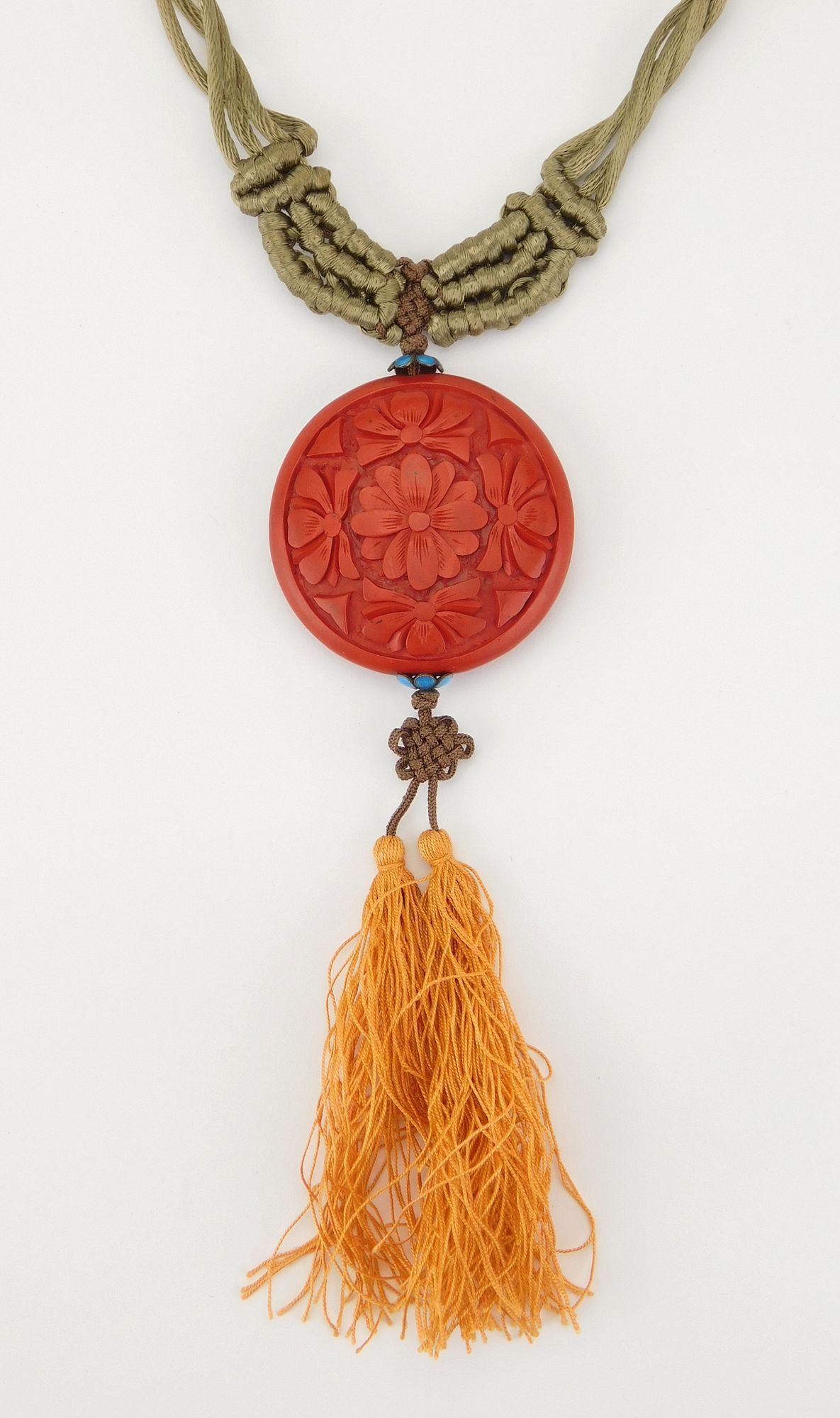 Artwork by Simone Samuels, Macramé and cinnabar necklace- intricately woven necklace with a carved cinnabar round pendant, Made of carved cinnabar
