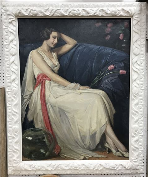 Lady in white dress with red sash, a glass vase in foreground by Nestor Cambier