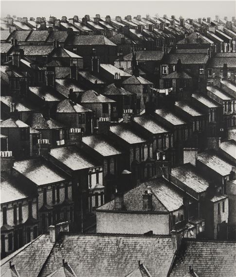 A high-angle view of a dense urban neighborhood with rows of terraced houses.