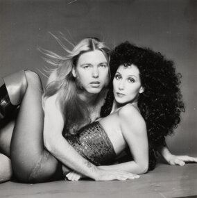 A black-and-white portrait of two figures in contrasting hairstyles and textures.