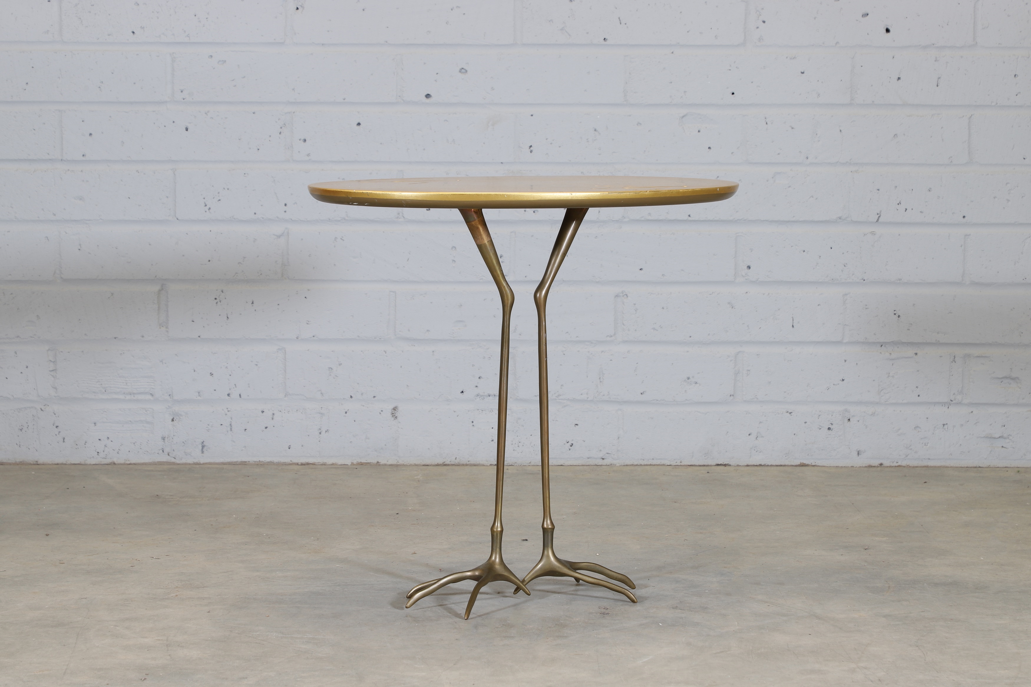 c.1980 designed by Méret Oppenheim in 1939 with an oval gold-leaf top with two footprints raised on cast bronze stork legs - Meret Oppenheim
