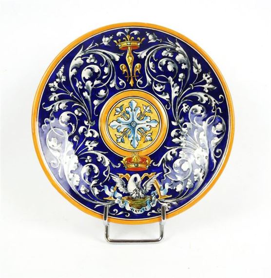Circular earthenware dish with rinceaux decoration on a blue background