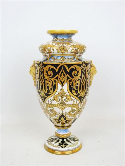 Polychrome earthenware pedestal vase with lustrous gilded lambrequin decoration on a white and black ground, two mascarons form handles
