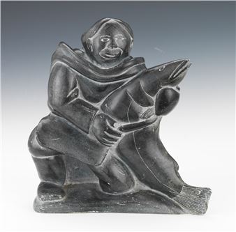 Traditional large heavy Inuit carved stone of a man with a large fish sculpture - Lui Escoto