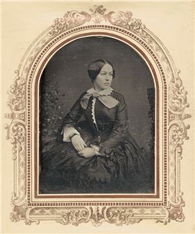 A formal portrait of a seated woman in a dark dress within an ornate decorative frame.