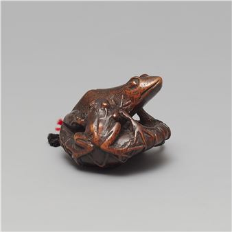 A wood netsuke of two frogs sitting on a lotus leaf - Gyokushu