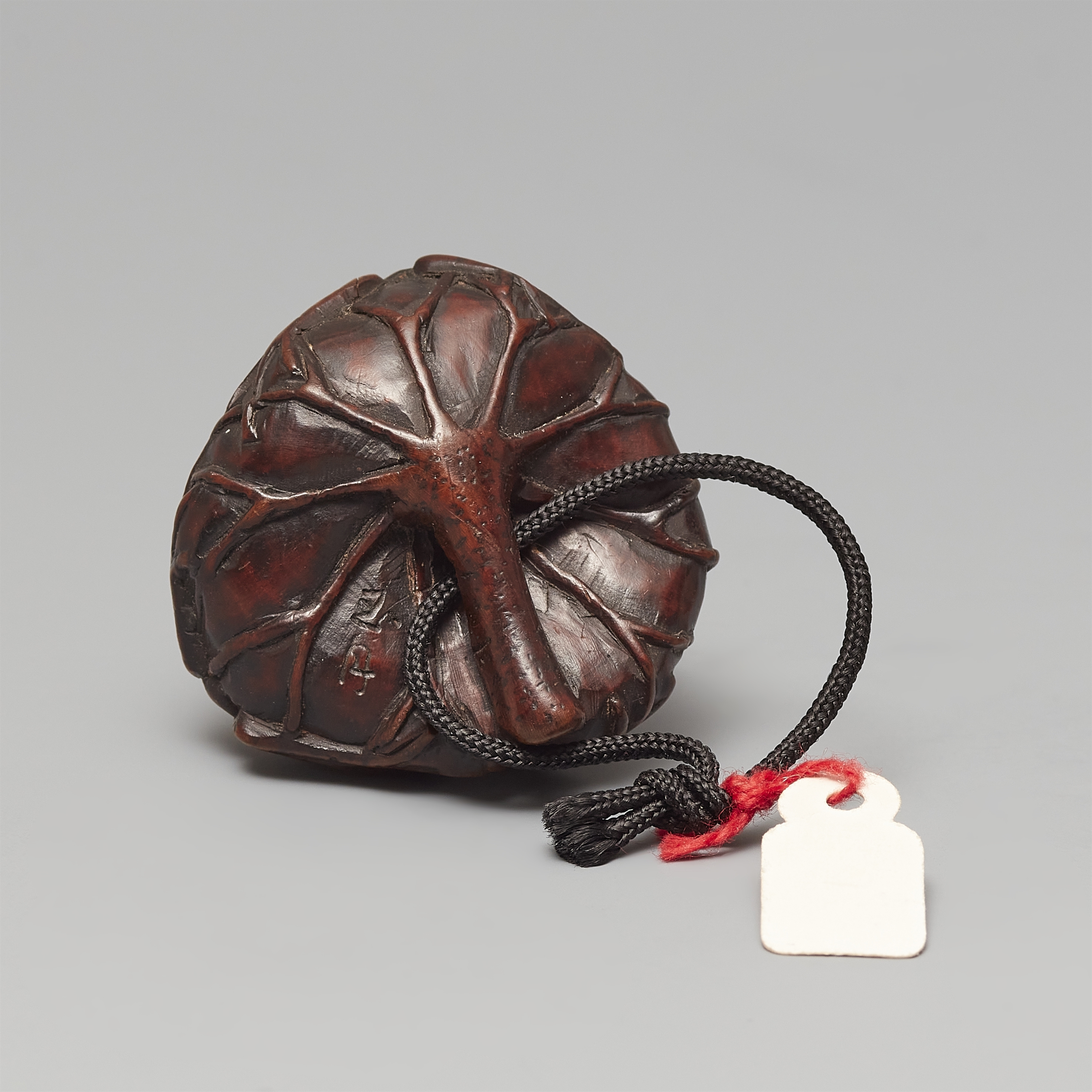 Artwork by Gyokushu, A wood netsuke of two frogs sitting on a lotus leaf, Made of black horn