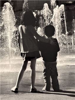 Two children in front of the fountain - Brusson Eric