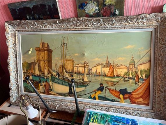A framed maritime scene depicting a busy harbor with boats and figures against a city skyline.