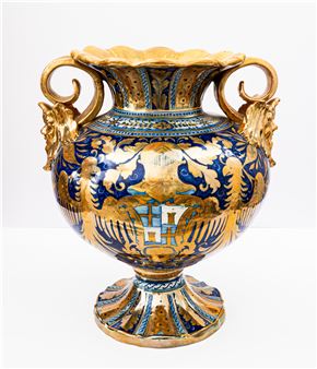 Grande vaso biansato a lustro metallico di forma globulare decorato con mascheroni a rilievo e anse a volute. Campo con decoro araldico con - Alfredo Santarelli