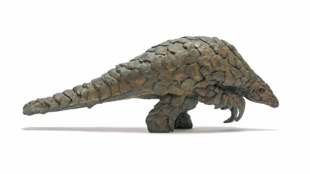 Artwork by Robert Rorich, Pangolin Boy, Made of bronze with a brown patina