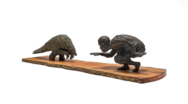 Artwork by Robert Rorich, Pangolin Boy, Made of bronze with a brown patina