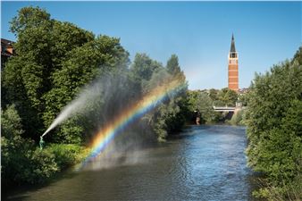 A Hooded Bronze Figure Sends Rainbows Wafting Across the River Enz